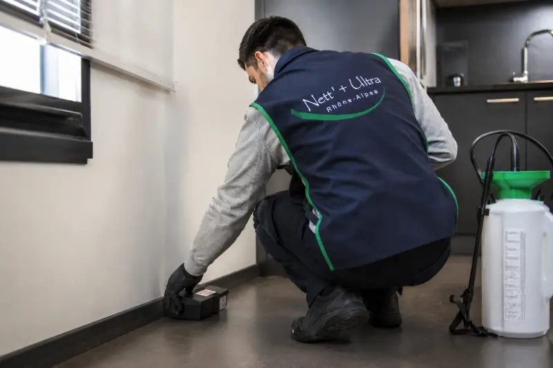 dératisationwebp agent d'entretien nettoie une poubelle extérieure